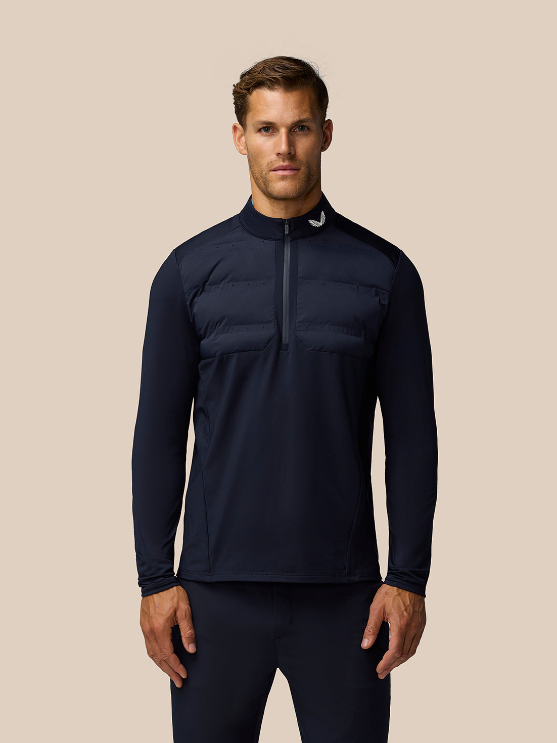 Front view of a man wearing the Golf Pinnacle LVS Hybrid 1/2 Zip Top in midnight navy with a padded chest panel and layered ventilation