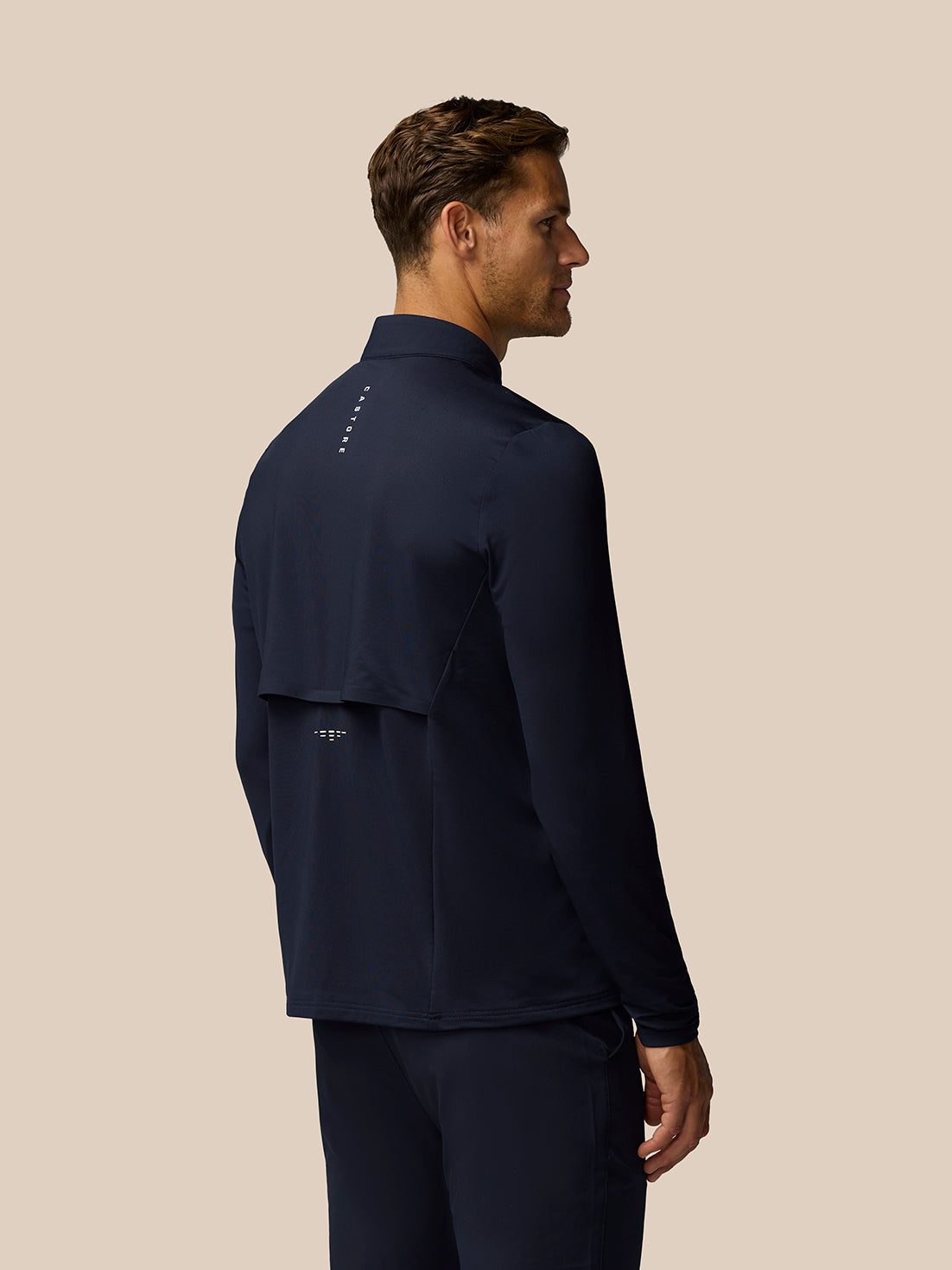 Back view of the navy Golf Pinnacle LVS Hybrid top showing layered back panel and subtle branding
