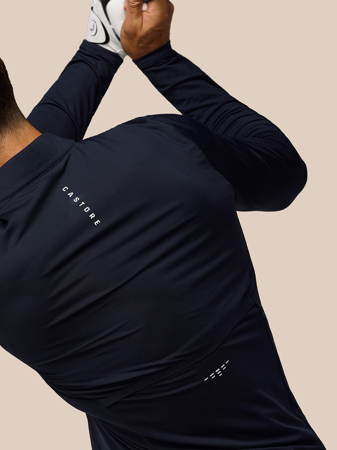 Close up of the navy golf top showing Castore branding on the back shoulder with ventilation detailing.