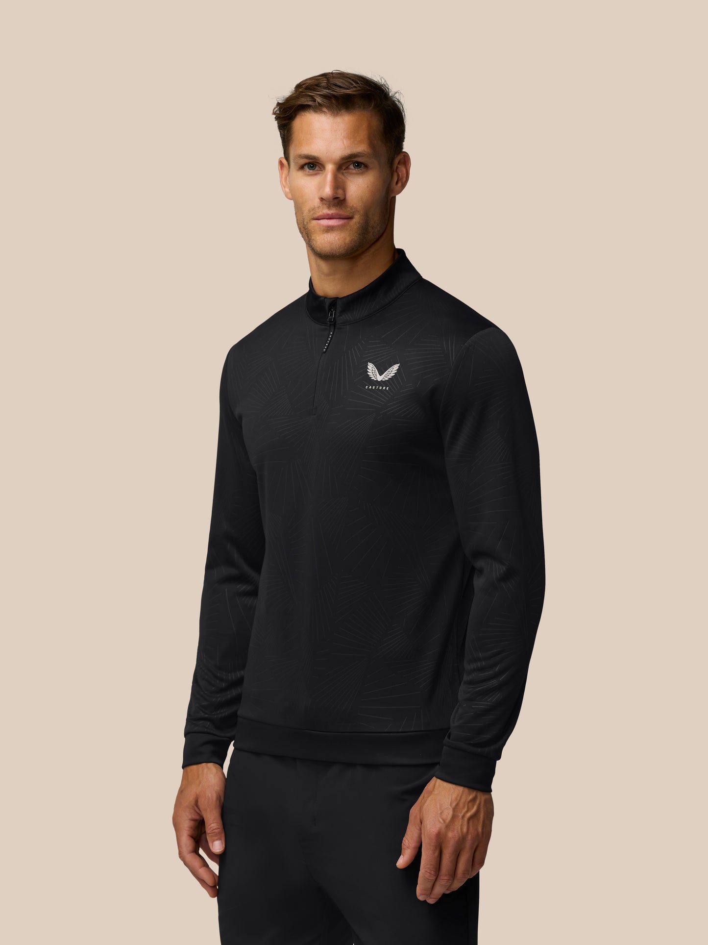 Male model wearing black Golf Club Classic 1/4 Zip Debossed Top with white Castore logo on chest.