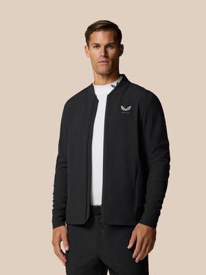 Front view of a man wearing a black Golf Pinnacle LVS Jacket with the Castore logo on the left chest