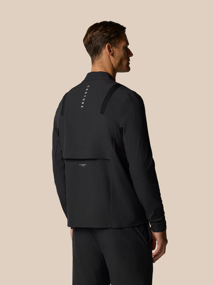 Back view of a man wearing a black Golf Pinnacle LVS Jacket with vertical Castore branding down the back and shoulder details