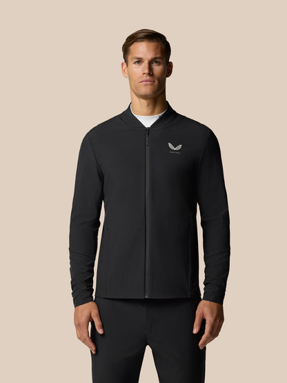 Man wearing black Golf Pinnacle LVS jacket with full front zip and Castore logo on the left chest.