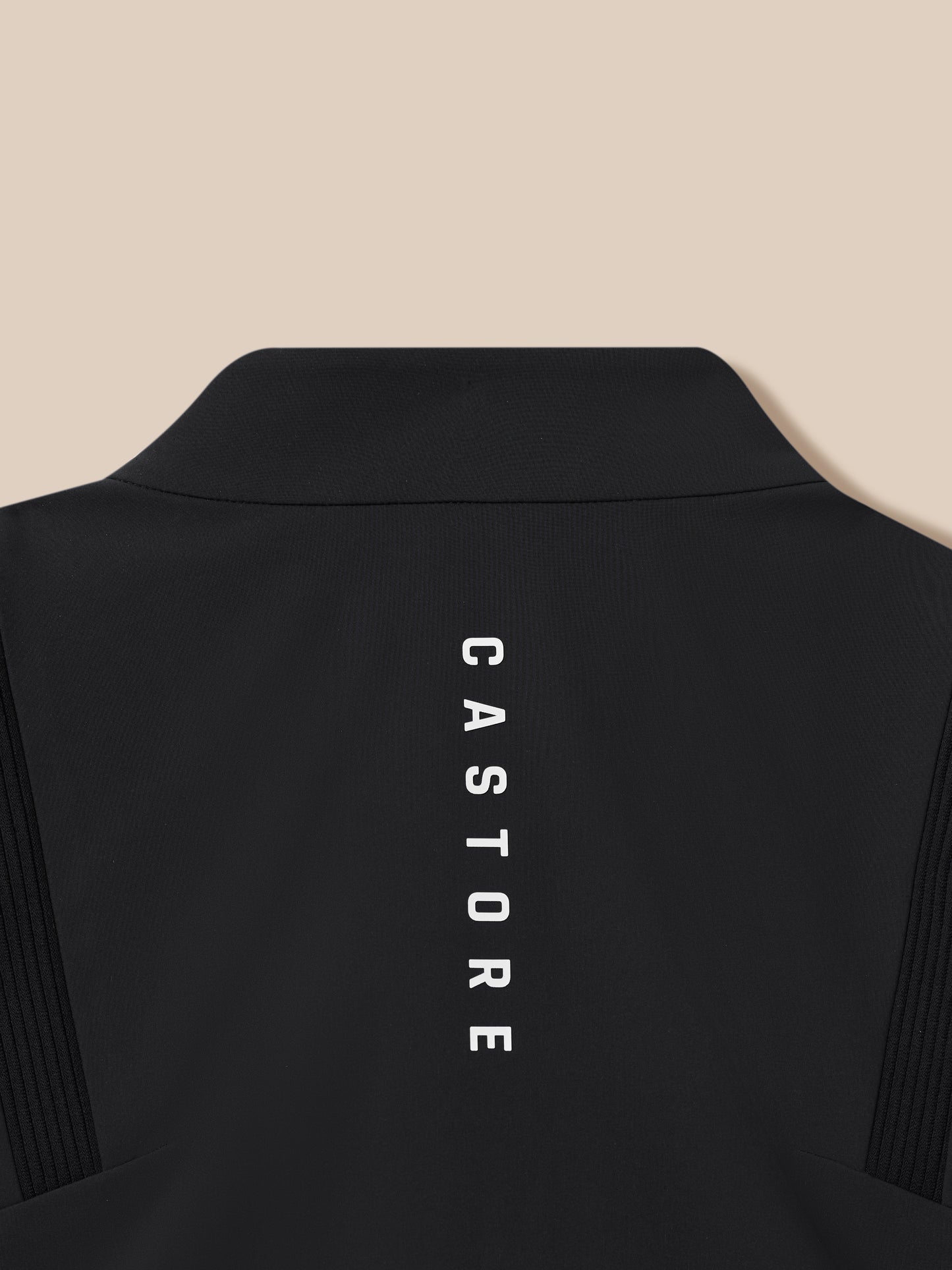 Close up of the black Golf Pinnacle LVS jacket neck area with textured fabric and vertical Castore branding.