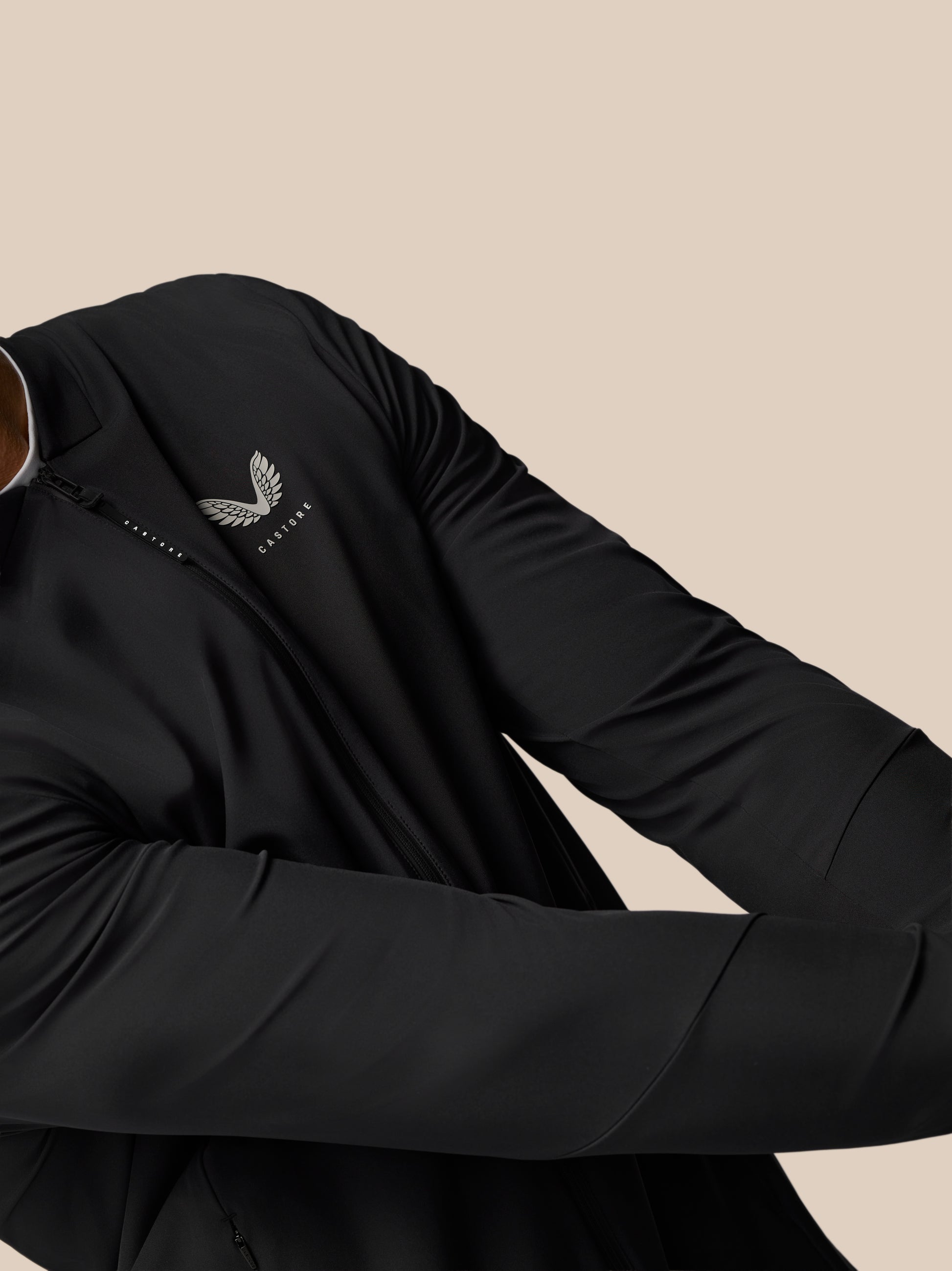 Close-up of the black Golf Pinnacle LVS Jacket featuring a front zipper and Castore logo on the left chest.