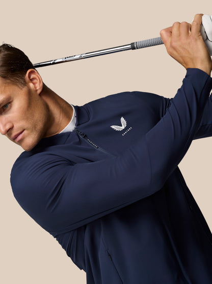 Close up of golfer in navy Layered Ventilation System jacket gripping a club behind his head mid swing