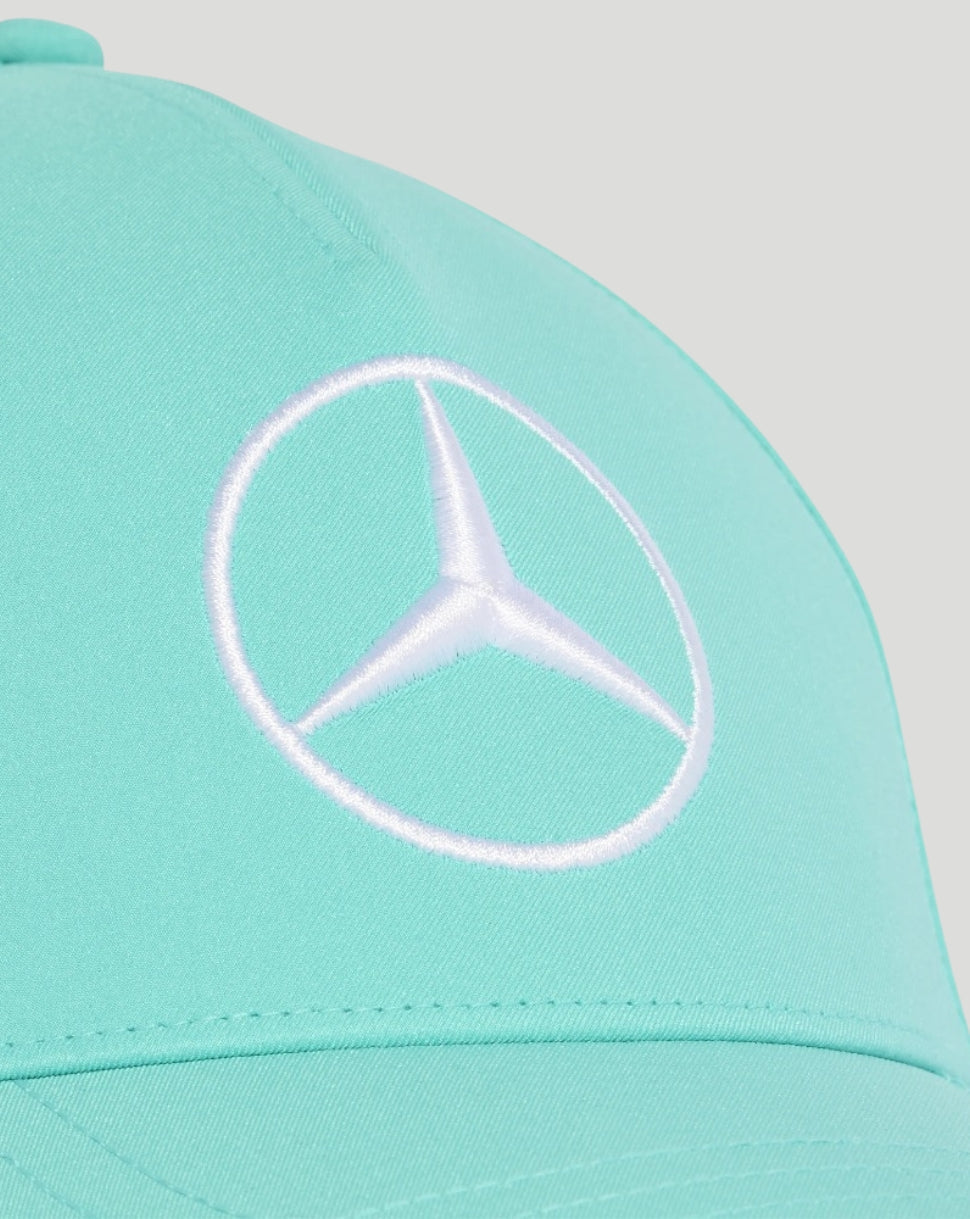 A close-up of a mint green baseball cap featuring a white embroidered Mercedes-Benz logo on the front.