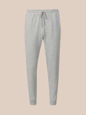 Light gray heather jogger sweatpants with an elastic waistband, drawstring, and ribbed ankle cuffs, shown against a solid beige background.
