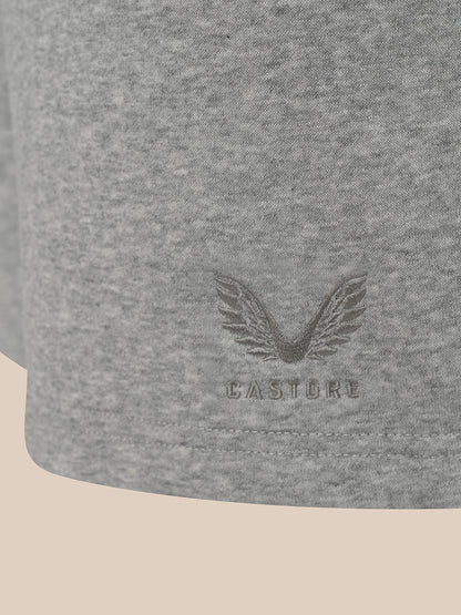 Close-up of a heather gray fabric product, likely a sweatshirt or jacket sleeve, featuring an embossed winged logo and the brand name CASTORE.