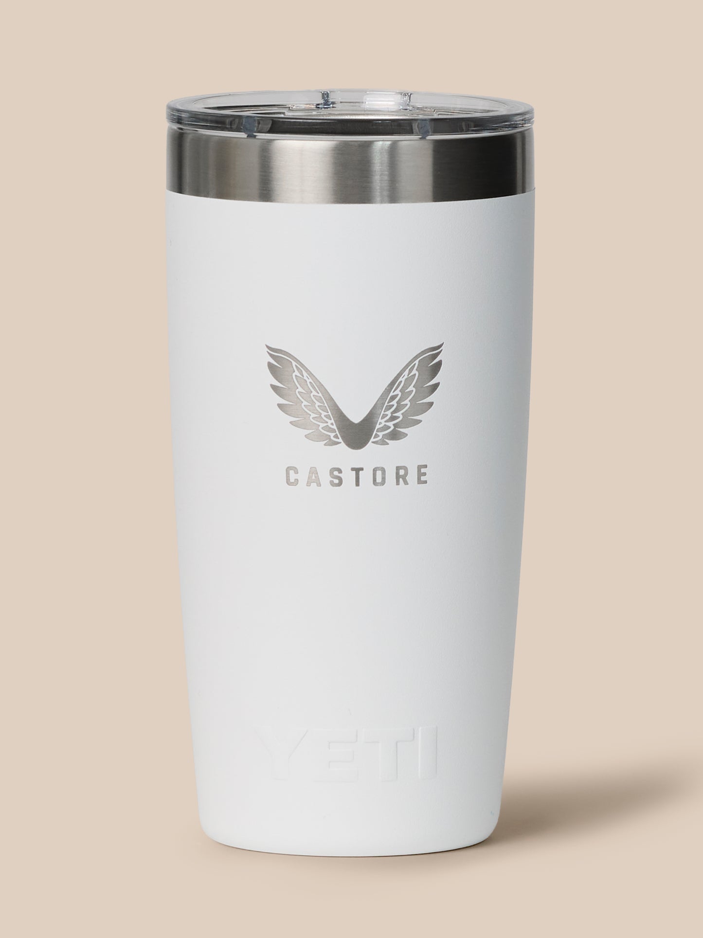 Close up of white YETI Castore tumbler with clear lid and silver lip, showcasing the Castore wings logo.