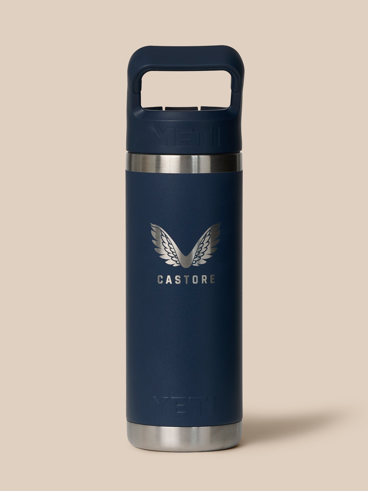 Close-up of YETI x Castore Rambler 532ml navy bottle showing embossed YETI logo on cap and a silver neck band