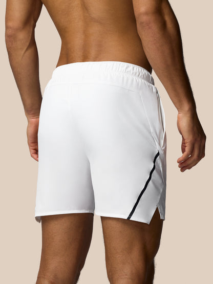 White athletic shorts with a black stripe on a beige background