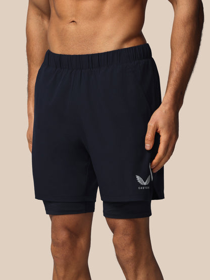 Navy blue athletic shorts with a logo on a beige background