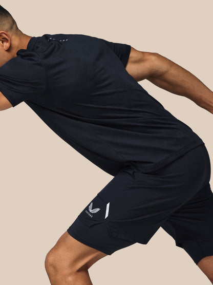 Man wearing navy athletic outfit with brand logo on beige background