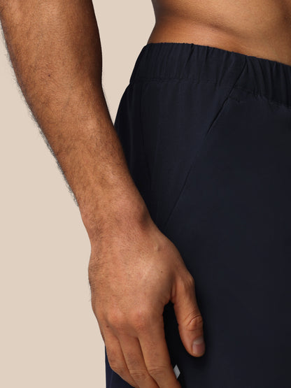Person wearing black pants with a neutral background