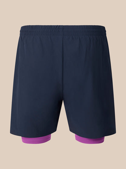 Dark navy athletic shorts with a built-in purple compression liner visible at the legs, shown against a solid beige background.