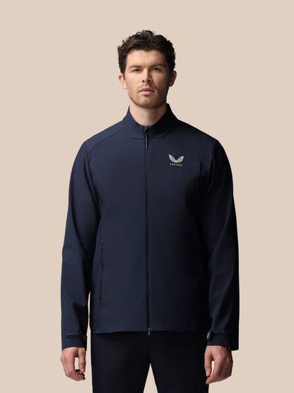 Close up of male model in navy Castore LVS woven jacket with chest logo and zip front.