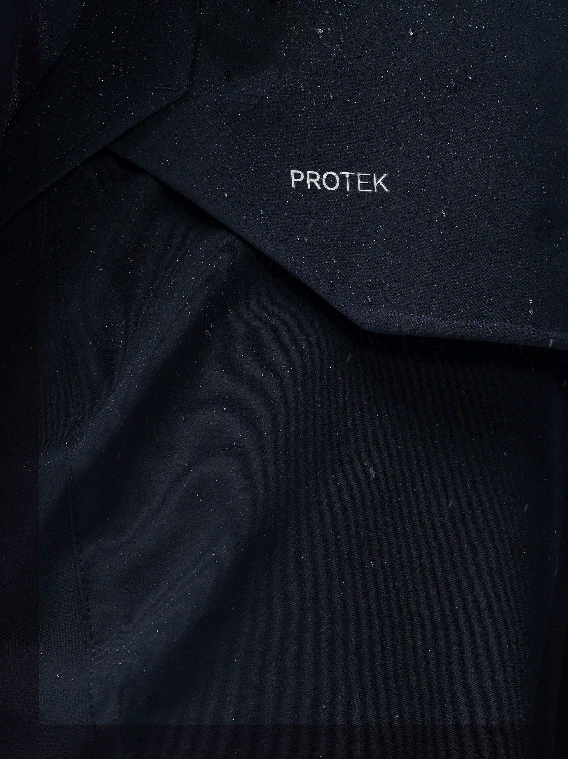 Close-up of navy jacket fabric with PROTEK branding