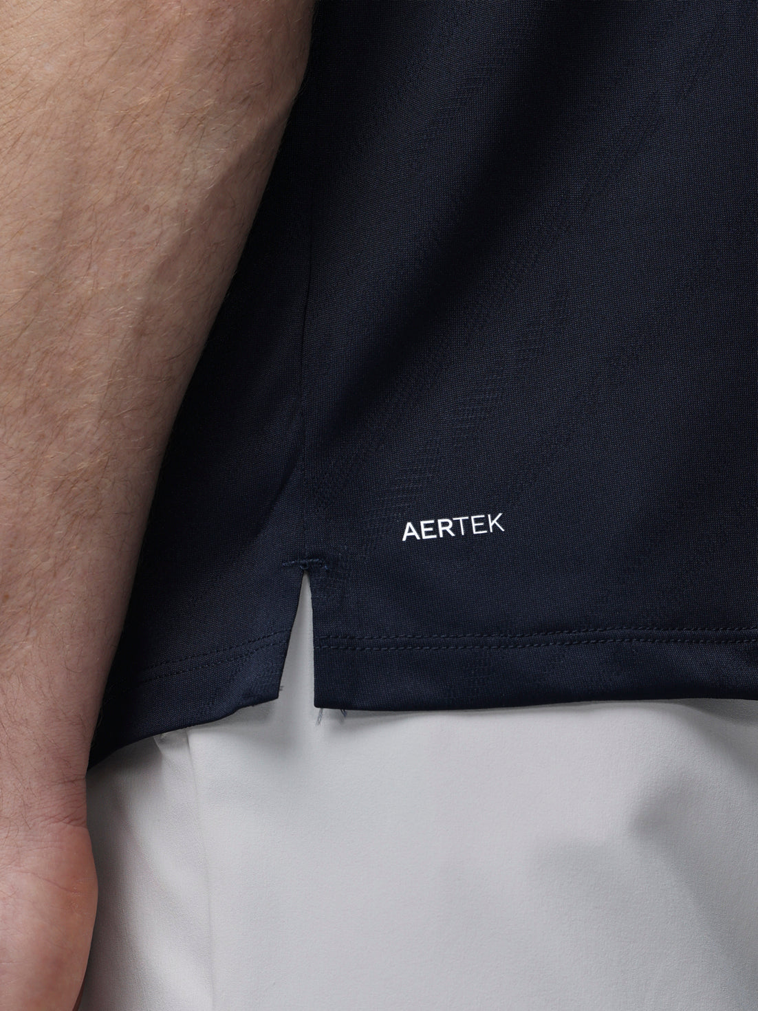 Navy LVS Engineered Knit Short Sleeve Polo Top laid flat with AERTEK branding at the hem