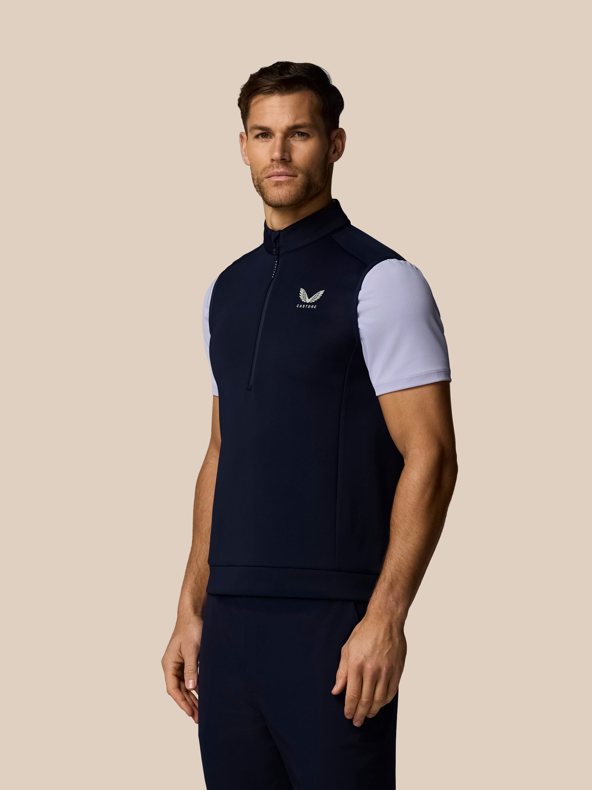 Male model wearing navy Golf Flex Half Zip Gilet with Castore logo on chest