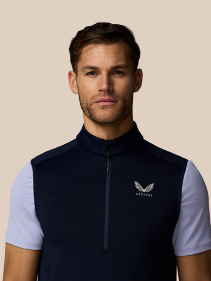 Male model wearing navy golf Flex Half Zip Gilet with light blue sleeves, front zipper and Castore logo on chest.