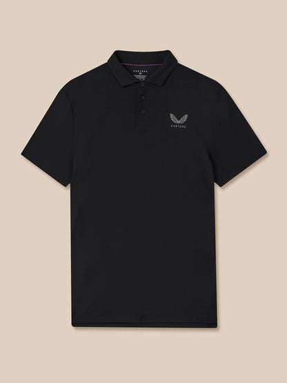 Close up of a man wearing a black Castore golf polo with left chest logo and pink collar trim