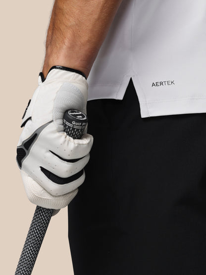 Person wearing a white golf glove holding a golf club with 'AERTEK' branding on clothing.
