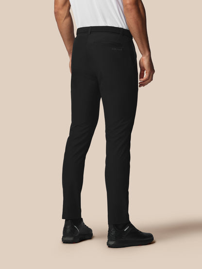 Back view of a man wearing black Castore golf trousers with a back welt pocket and Castore logo.