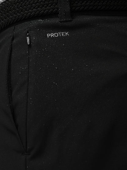 Close-up of a black jacket with 'PROTEK' branding on a dark background