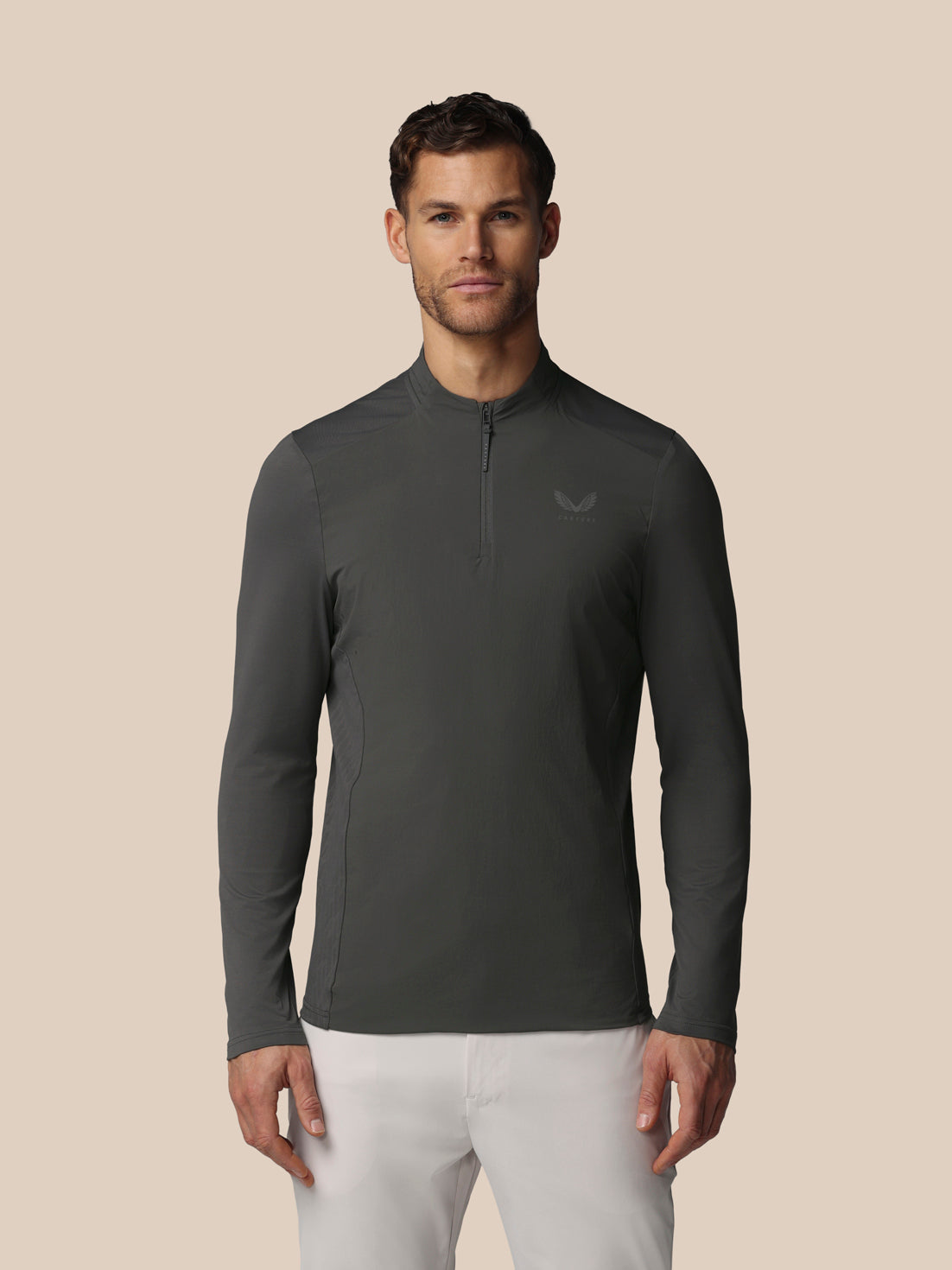 Front view of a man in gunmetal LVS Quarter Zip Long Sleeve Top with a zip collar and Castore logo on the chest.