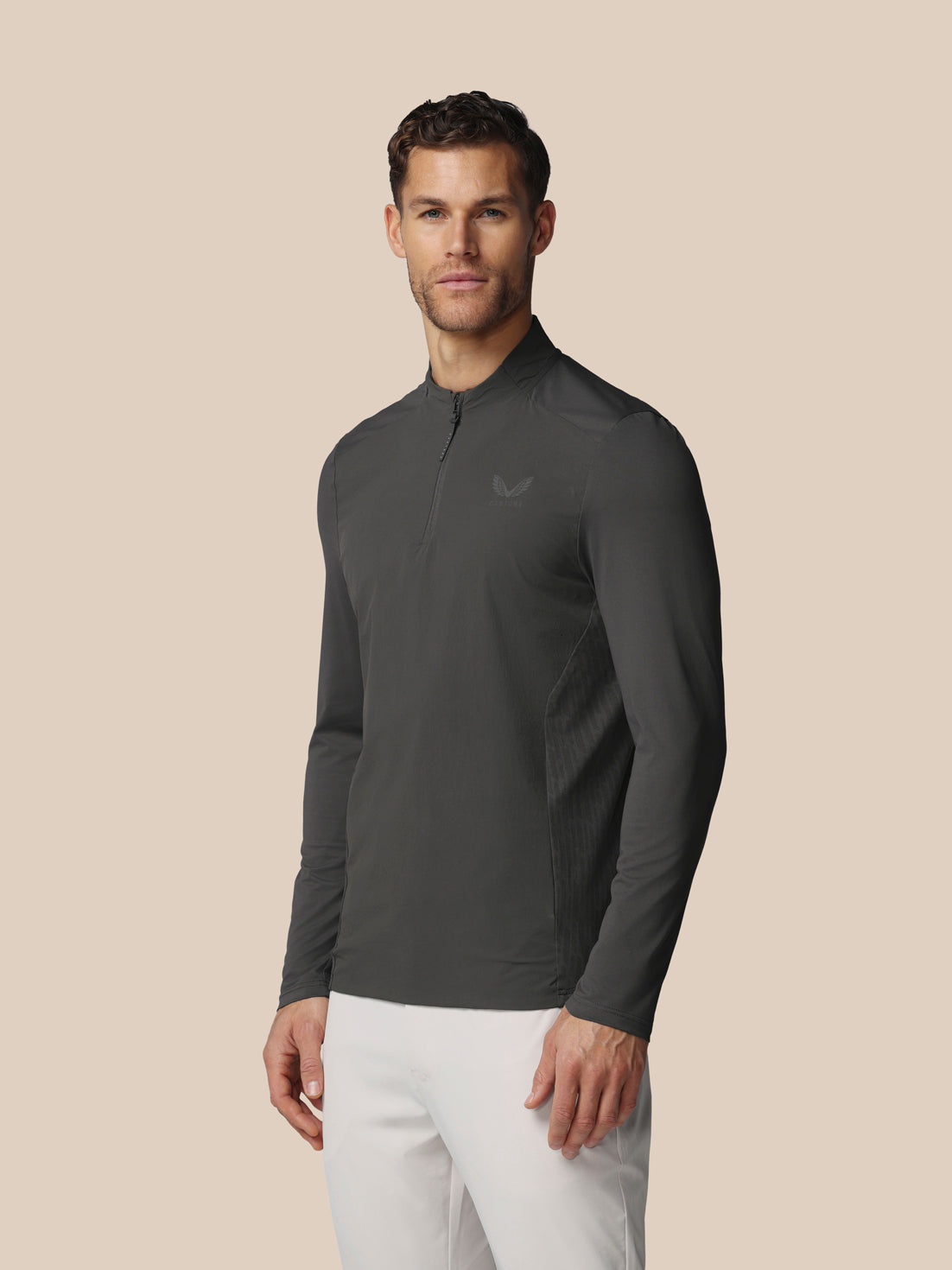 Male model wearing gunmetal LVS quarter zip golf top in a three-quarter pose highlighting side panels and zip collar