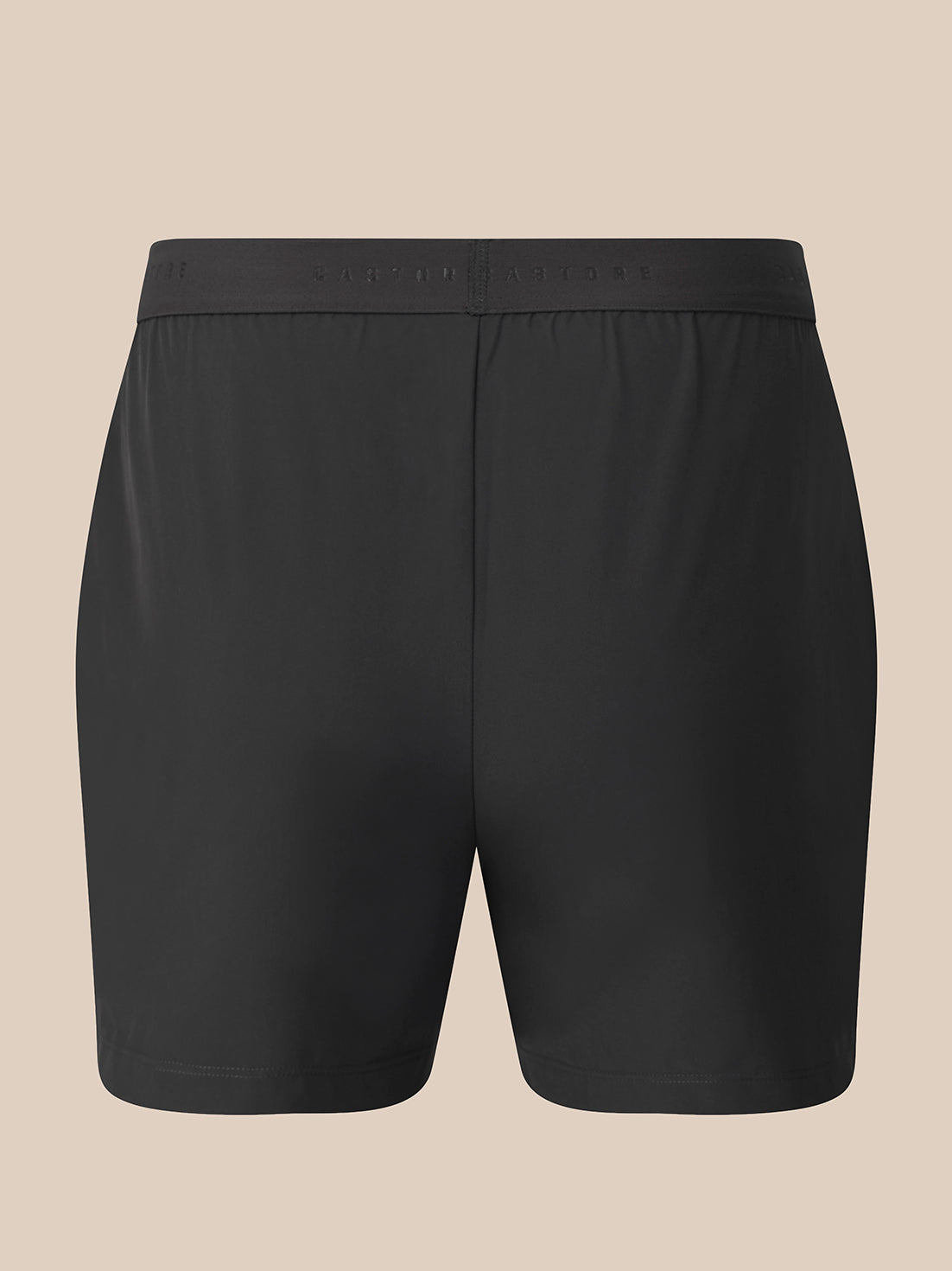 Black athletic shorts with a wide elastic waistband, shown flat against a solid beige background.