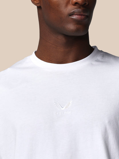 White t-shirt with a small logo on a beige background
