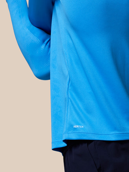 Close-up of blue athletic long sleeve top showing textured fabric and AERTEK branding at the hem.