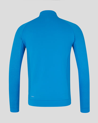 Back view of bright blue Majesticks golf club long sleeve flex top with stand collar and ProTek label at back hem.