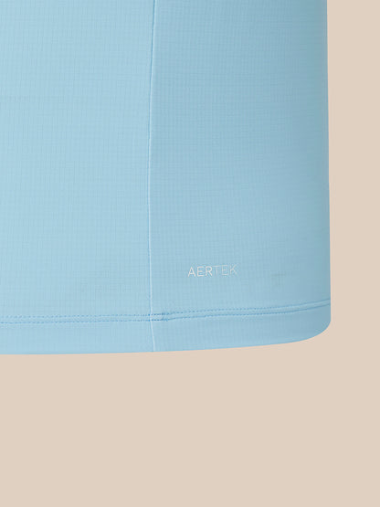 A close-up of a light blue athletic fabric panel with a fine grid texture, featuring the AERTEK logo printed in white near the bottom hem, set against a solid beige background.