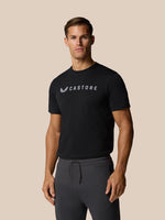 Front view of a man wearing a black Castore graphic lifestyle T-shirt with a wordmark on the chest