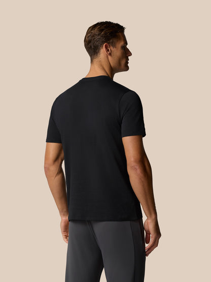 Back view of a man wearing a black Castore graphic lifestyle T-shirt