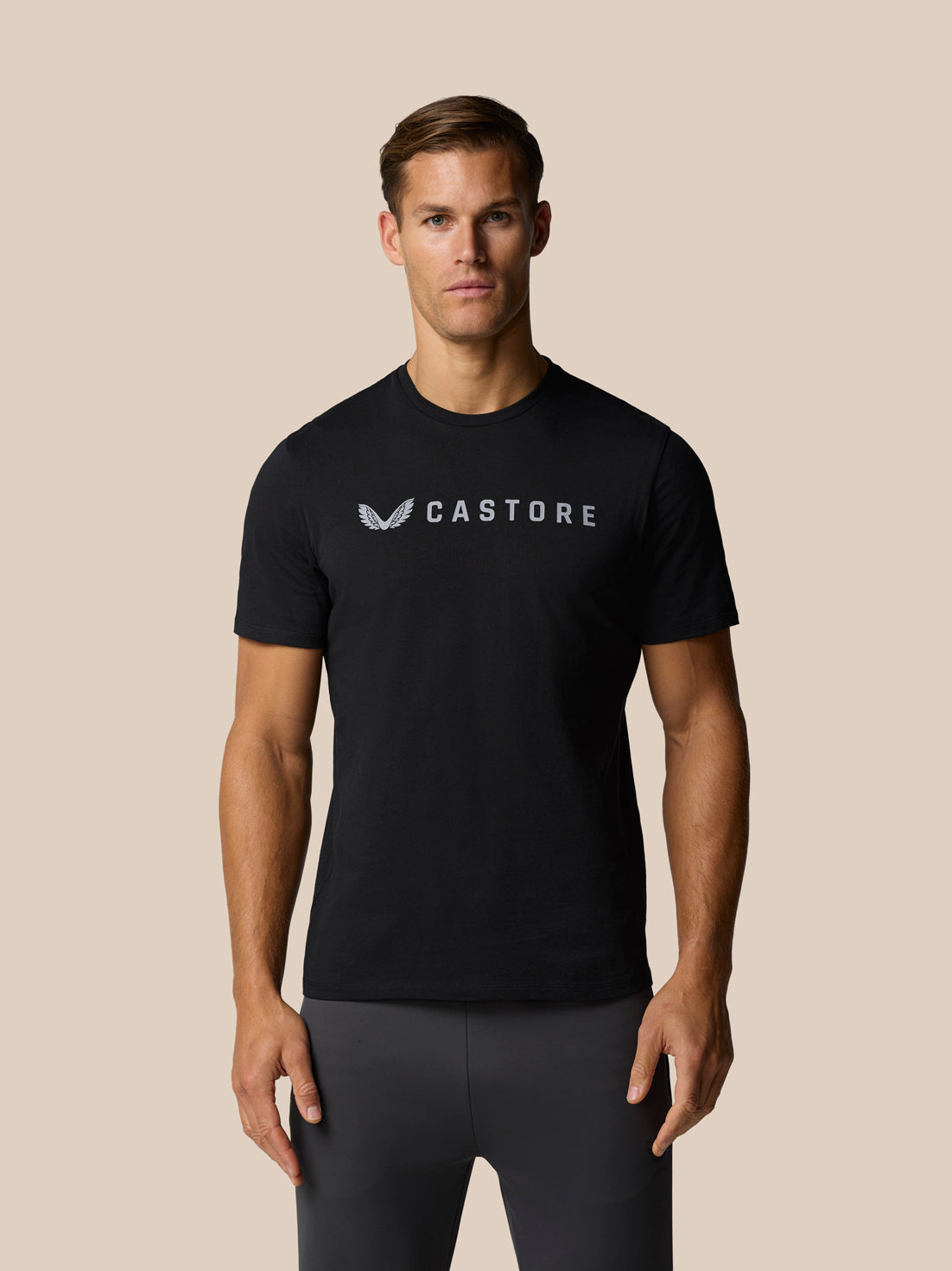 Close-up of a man wearing a black Castore T-shirt with a chest logo.