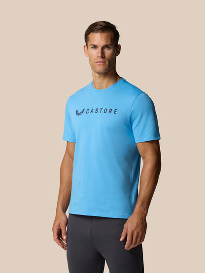 Man wearing cool blue Graphic Lifestyle T-Shirt with Castore wordmark across the chest.