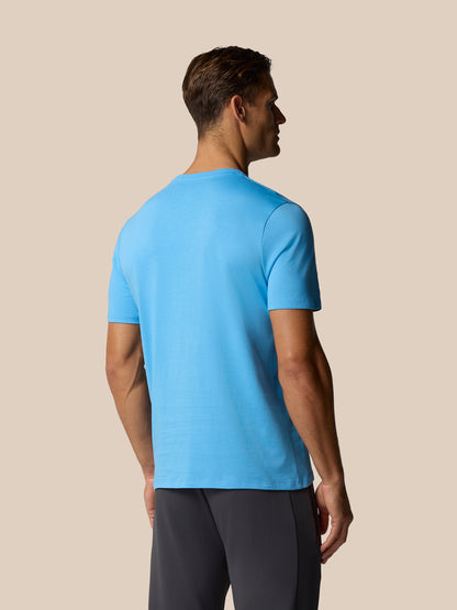 Three quarter view of man in blue Castore graphic lifestyle T-shirt showing front logo