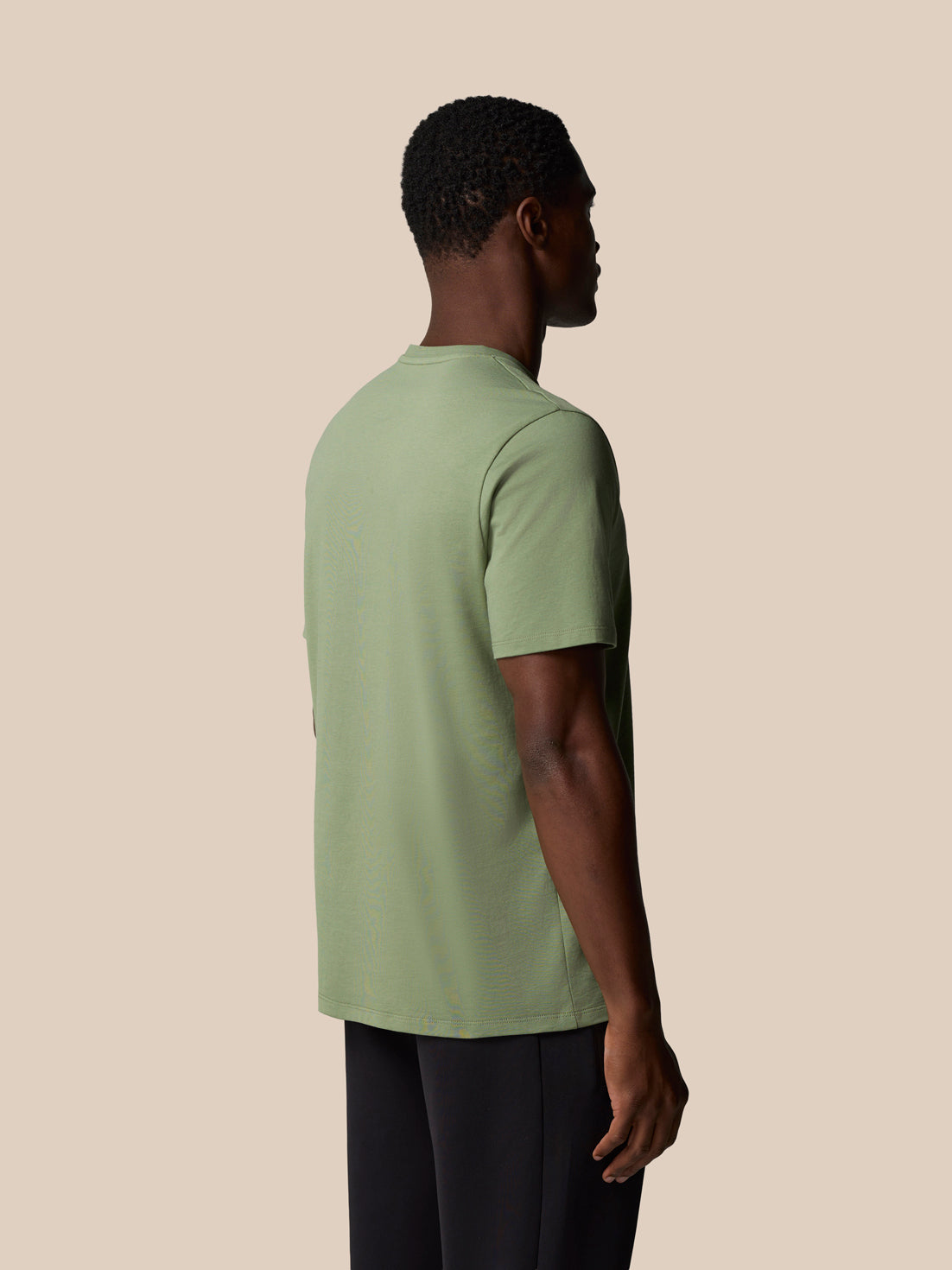 Back view of thyme green 100% cotton short sleeve T shirt on a male model.