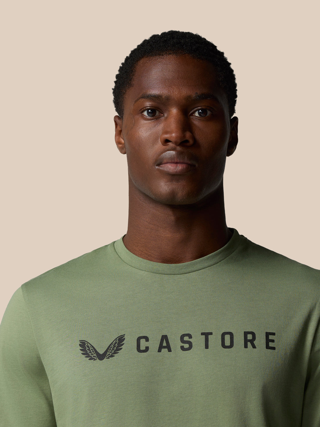 Close-up of the thyme green Castore Graphic Lifestyle T Shirt showing the Castore wordmark on the chest.
