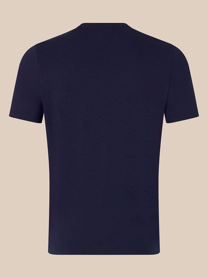 A plain navy blue short-sleeve crewneck t-shirt shown from the back, displayed on a solid light beige background.