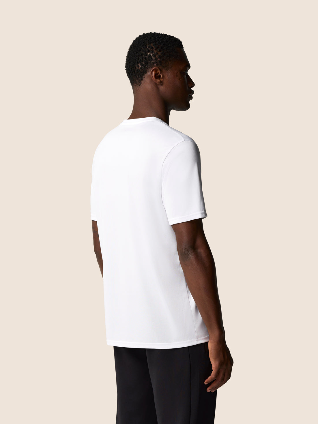 Back view of a white Castore graphic training T shirt on a male model