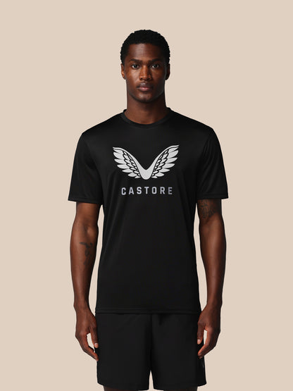 Man wearing a black t-shirt with 'Castore' logo on a beige background