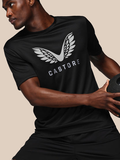 Person wearing a black t-shirt with 'Castore' logo holding a medicine ball.