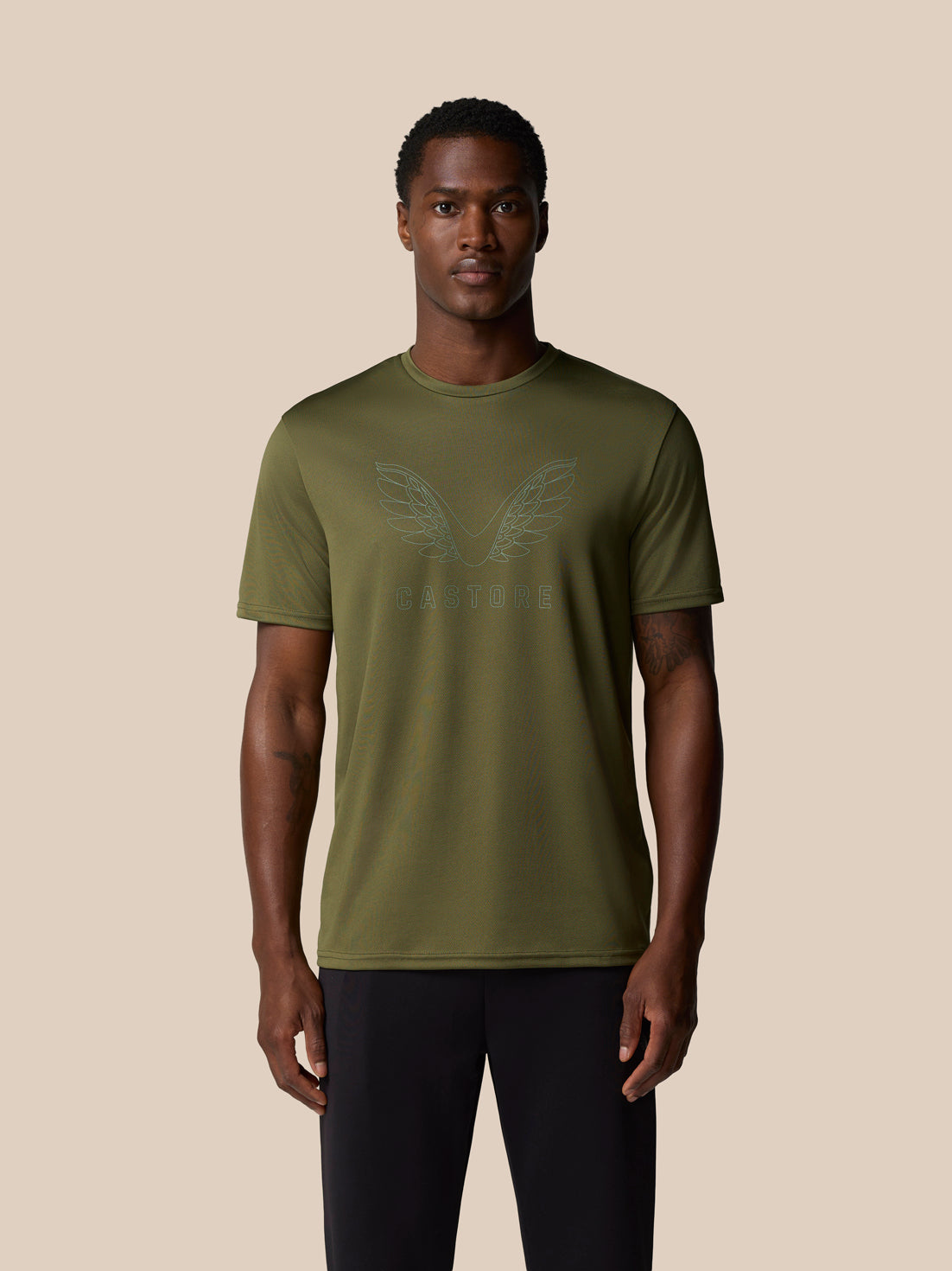 Male model wearing ivy green Graphic Training T Shirt with subtle wings graphic on chest