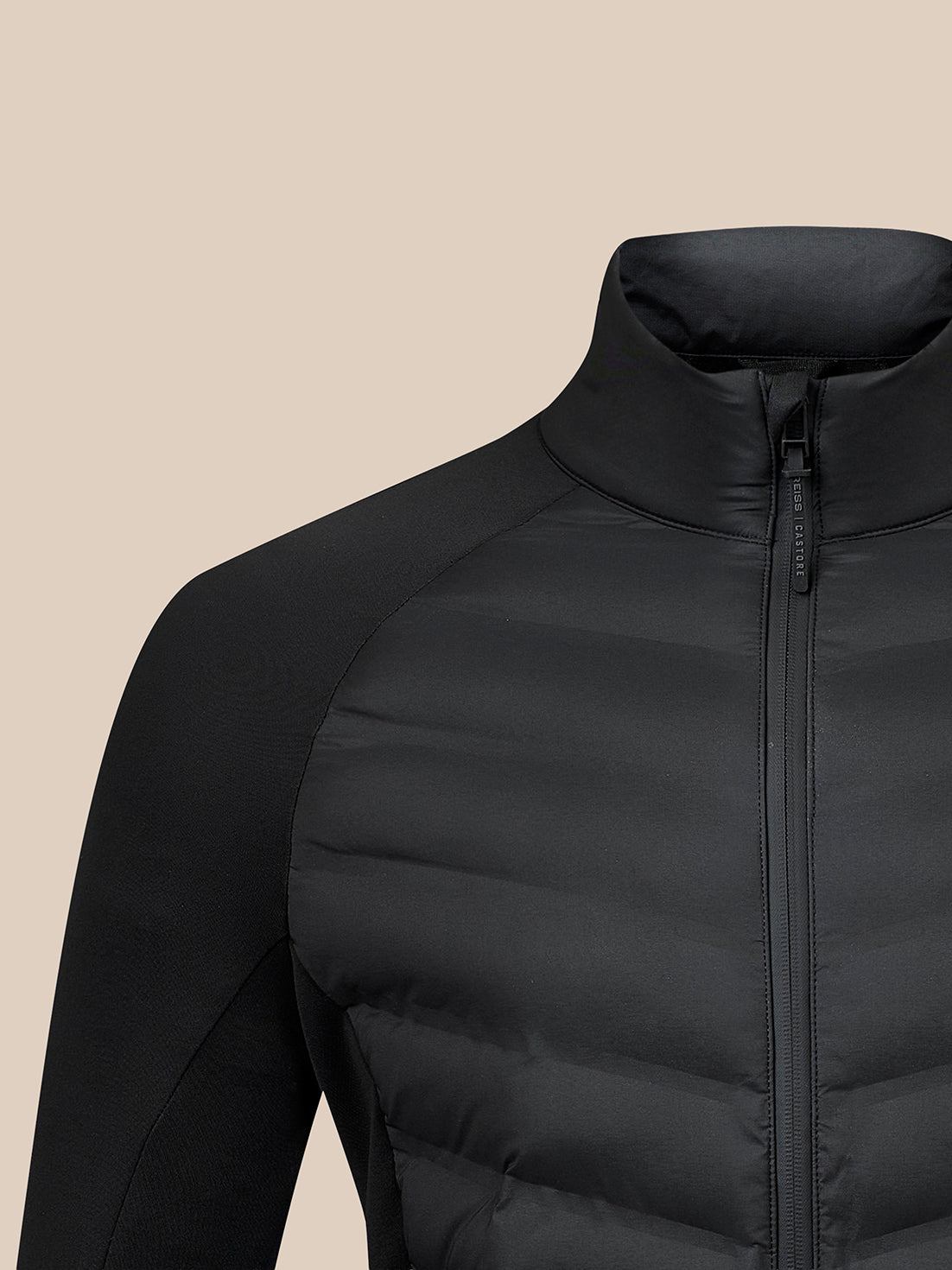Close-up of a black puffer jacket with a high stand-up collar and front zipper, shown on a plain beige background.