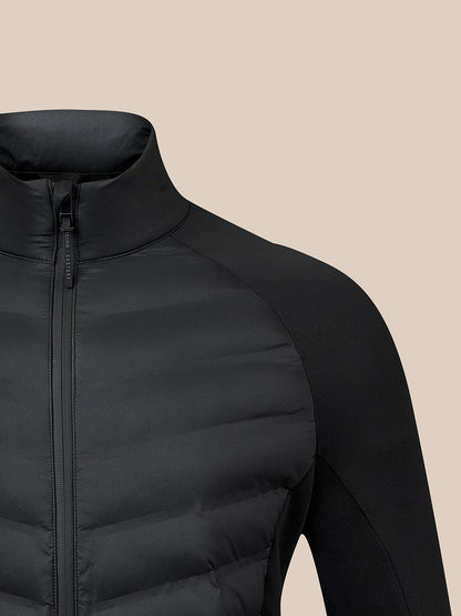 Close-up of a black puffer jacket with a high collar and front zipper, shown against a solid beige background.